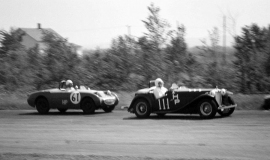Jack Lawrence #61 in an Austin-Healey Sprite racing at the Dunkirk Airport in 1963.