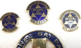 Various service pins awarded to Ramsay Riddell by National Ski Patrol.