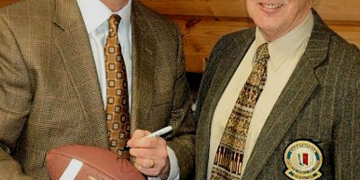 Don Beebe autographs a football for CSHOF director Jim Painter.
