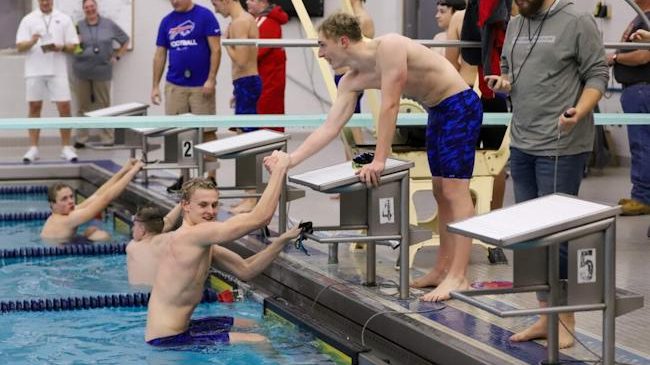 Brady Lindstrom helps Gannon Moore out of the pool.