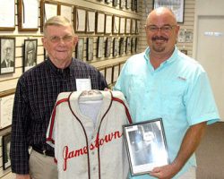 Chautauqua Sports Hall of Fame board member Russ Ecklund,
left, accepts from Ted Wyberanec a jersey his father wore as a member of the Jamestown Merchants. Photo courtesy of Scott Kindberg. Russ Ecklund, left, accepts from Ted Wyberanec a jersey his father wore.
