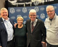 Tom Anderson (Class of 2025) and Sheilah Gulas (Class of 2018) are flanked by Tom's brothers. Tom Anderson (Class of 2025) and Sheilah Gulas (Class of 2018) are flanked by Tom's brothers.