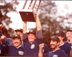Bob Schmitt holds up the trophy after the Jock Shop won the 1984 modified softball national title. Pictured in front right is Joe Mistretta. 1984-Jock-Shop