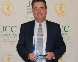 The Distinguish Jayhawk award is presented to someone that has had a large impact on Jamestown Community College Jayhawk athletics over the years. Here Scott Kindberg displays the Distinguished Jayhawk award he received on May 6, 2025 at the JCC athletics banquet. cott Kindberg displays the Distinguished Jayhawk award he received.