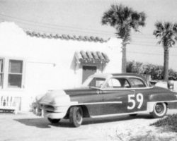 1952 Chrysler owned by Julian Buesink that Moore drove in the
1952 Daytona NASCAR race. He started second and finished tenth.
Note how the front of the car is taped up to protect the paint from
the sand-blasting effect of racing on the beach. Buesink probably
planned to resell the car on his used car lot. The car is parked in
front of a motel where they stayed during their time in FL. They
drove the car back and forth to the race course. They most likely
drove it from Findley Lake to Daytona Beach and back as well. 1952 Chrysler owned by Julian Buesink that Moore drove in the 1952 Daytona NASCAR race.