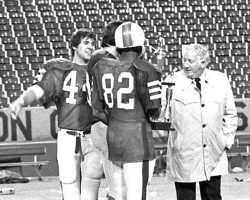 From the left, Sam Restivo, Randy Ordines and Vince Davis accept the championship trophy after Jamestown High School won the Section VI football title at Rich Stadium. <em>Post-Journal</em> (Jamestown), November 1979. From the left, Sam Restivo, Randy Ordines and Vince Davis accept the championship trophy after Jamestown High School won the Section VI football title at Rich Stadium in November 1979.