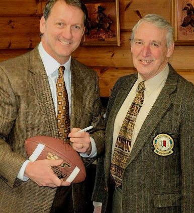 Don Beebe autographs a football for CSHOF director Jim Painter.