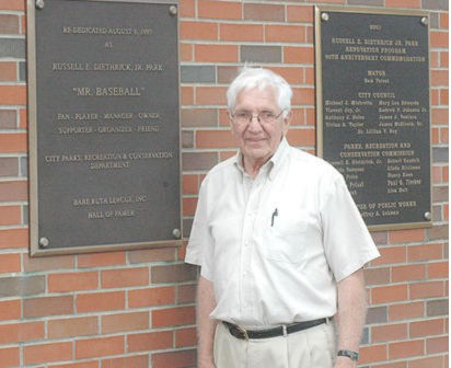 Russell Diethrick Jr. stands beside the plaque that bears his name.