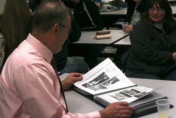 Sherman coach Mel Swanson flips through a scrapbook.