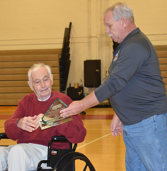 Marty Burroughs of IAABO Board 121 presents Roger MacTavish with award.