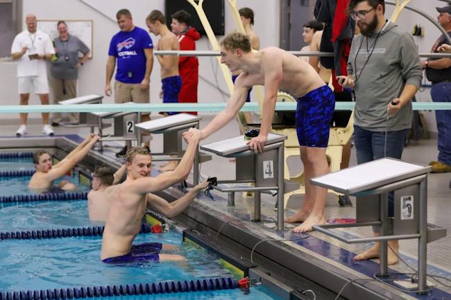 Brady Lindstrom helps Gannon Moore out of the pool.