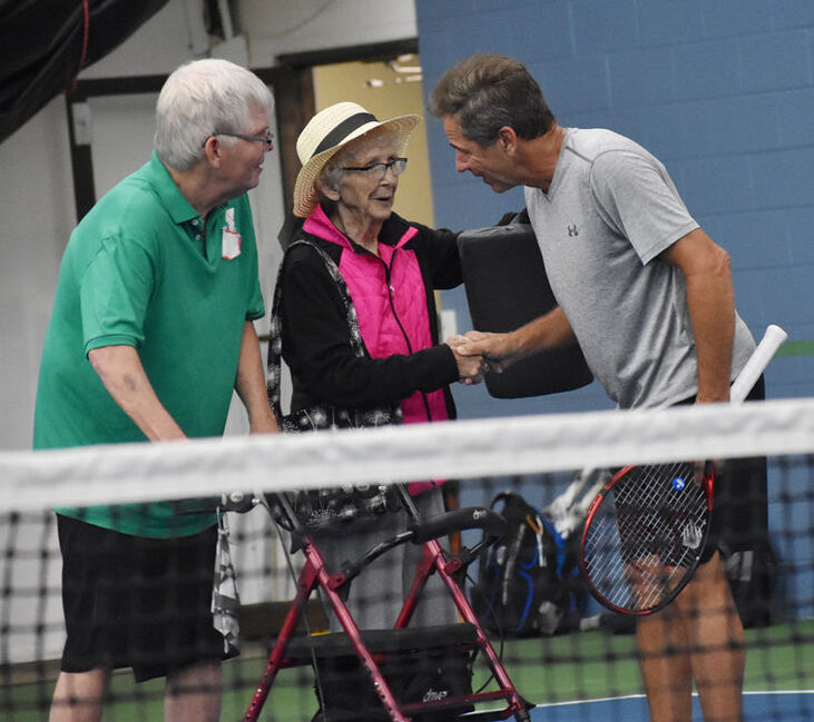 Tom Anderson escorts his mother, Nancy, onto the court where she is greeted by Jimmy Arias.