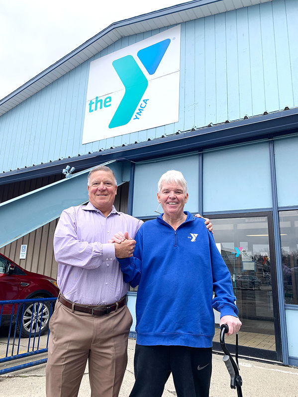 Tom Marra, left, and Tom Anderson, branch manager shake hands outside the Lakewood YMCA.