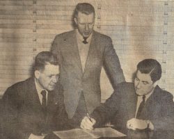 Marvin Olson signs the papers that made him manager of the Jamestown Falcons for 1946. Owner Johnny Jachym, seated left, looks on as does Business Manager Mark Hammond.