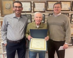 Bill Race (center) was honored by the Chautauqua County Visitors' Bureau for his exceptional service as a volunteer at the Chautauqua Sports Hall of Fame. Race has faithfully welcomed visitors every Friday afternoon for more than 20 years. Representing the CCVB were Scott Shelters (left) and Andrew Nixon (right). December 13, 2024.