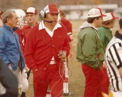 Joe Sanfilippo, wearing the headset. At left in blue jacket is his brother Sam. At right, over the official's shoulder, is Wally Huckno. Photo from 1982.