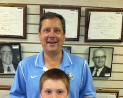 Chris Olsen and his son Ted posing at the CSHOF June 2014 with a photo of Ted's grandfather and namesake,Ted Olsen.